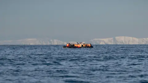 A generic shot of a small boat in the Channel with the White Cliffs of Dover in the background.