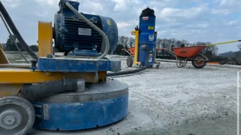 Guernsey Water Various builders tools and equipment are shown on top of concrete roof of a water storage tank