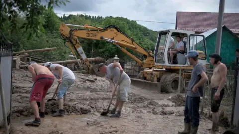 Getty Images Men clear the streets in the Ukrainian village of Lanchyn