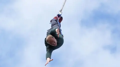 PA Media Liberal Democrat leader Sir Ed Davey taking part in a bungee jump during a visit to Eastbourne Borough Football Club in East Sussex, while on the General Election campaign trail