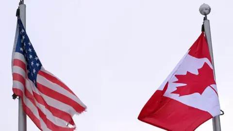 File image of the American and Canadian flags flying side by side