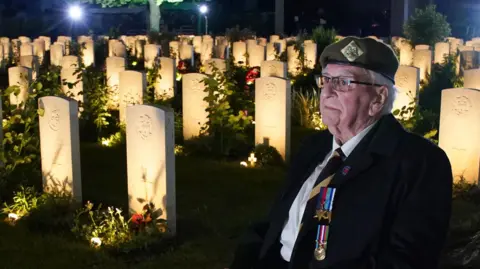 PA D-Day veteran Sergeant Richard Brock sits next to some of the 4,600 lit headstones during the Commonwealth War Graves Commission's Great Vigil to mark the 80th anniversary of D-Day at the Bayeux War Cemetery in Normandy, France.