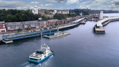 An artist's impression of the new landing at North Shields Fish Quay. It is an overhead shot of the small blue and white ferry going into port. There is a landing area with a walkway surrounded by blue steelwork. Houses line the quayside with trees and other buildings behind.