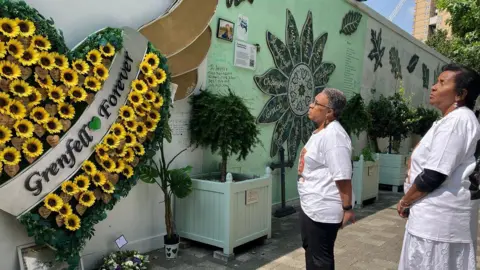 Jackie and Bernadette look at the memorial wall 