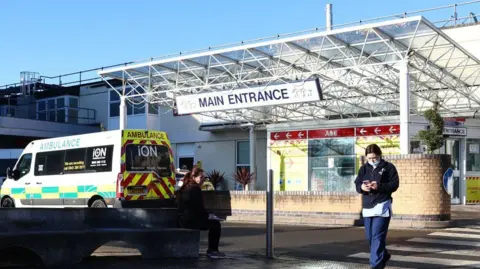 A member of the hospital personnel walks outside the Frimley Park Hospital in Surrey on January 13, 2022. 