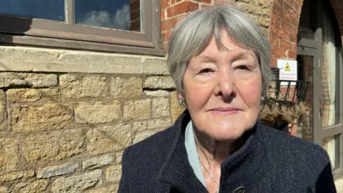 Mayor of Westbury, Sheila Kimmins, standing by a wall