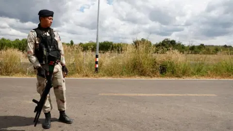 A Thai soldier stands on a road, with a field in the background (12/12/25)