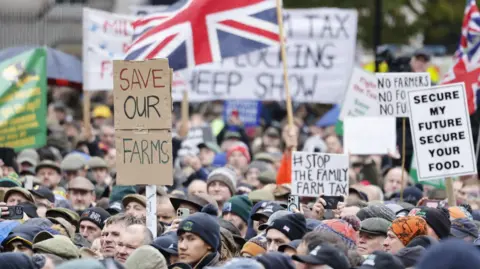 EPA A dense crowd of farmers take part in the protest in Whitehall. Many wear hats and carry signs 