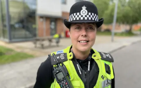 Sgt Gemma Rutter wearing police uniform and standing in front of Trowbridge Police Station