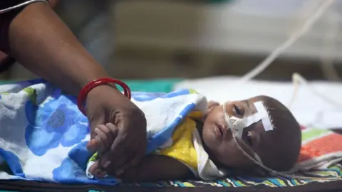 AFP An Indian woman holds her child's hand at the encephalitis ward of the the Baba Raghav Das Hospital in Gorakhpur, in the northern Indian state of Uttar Pradesh, on August 14, 2017