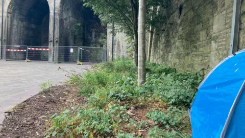 A blue tent pitched just yards away from the fenced off archways