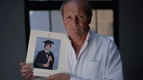 Derek Jones holding photo of son