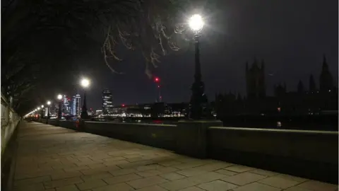 Getty Images A picture taken on March 27, 2021 in central London shows the Palace of Westminster (R), home to the Houses of Parliament which include the House of Lords and House of Commons, submerged into darkness