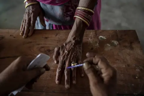 AFP An Indian woman has her finger inked by an election worker before voting in 2014.