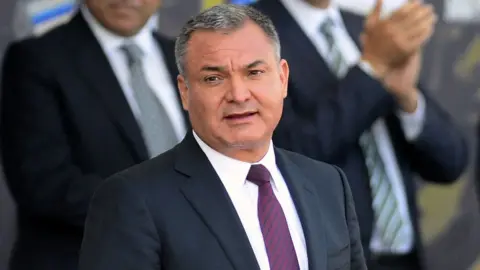 Man stands during a ceremony.