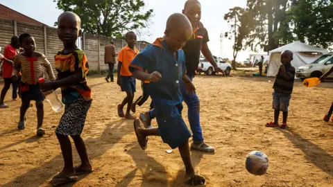 AFP Young boys who just received a vaccine against cholera play football in Harare, Zimbabwe, on 5 October 2018
