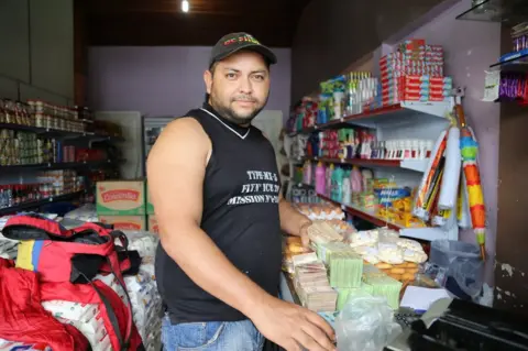 BBC William Camero buys sugar in a shop in Pacaraima