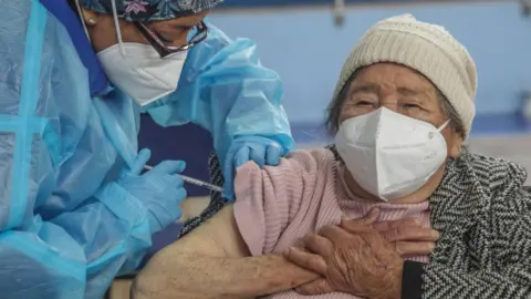 Getty Images A woman is given a dose of vaccine in Cuenca