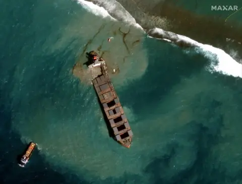 Maxar Technologies via Reuters Satellite image shows tug boats and Japanese bulk carrier MV Wakashio
