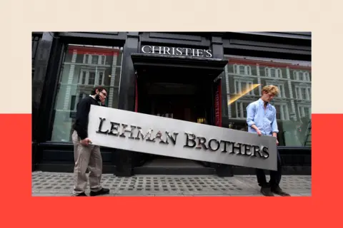 Getty Images Two people hold a sign for Lehman Brothers outside Christie's