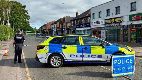 Leicester Media Online Leicestershire Police at the scene of an attempted theft of a cash machine from a building society on Sibson Road in Birstall on 6 May 2026, with a police sign stating the road is closed.