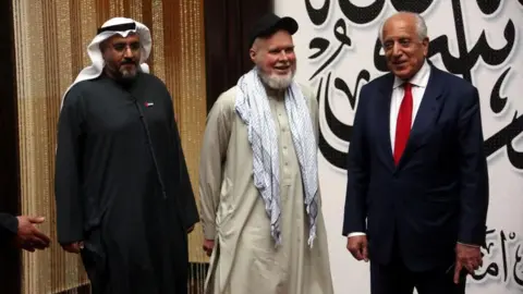 EPA Dennis Coyle, centre, with former US ambassador to Afghanistan Zalmay Khalilzad and UAE special envoy Saif Al Ketbi shortly after Coyle was released.