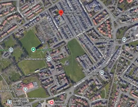 Google A screenshot of Google Maps showing an aerial view of the area around St Patrick's Primary school. The area is largely residential with a large field in the middle of the screen. This is the proposed site of the new school. A red pin to the north of the fields highlights where St Patrick's is located.