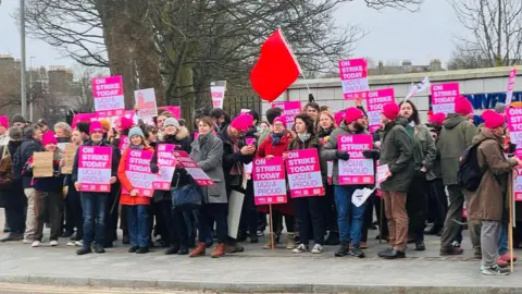 A picket line outside the University of Aberdeen, many with strike placards.