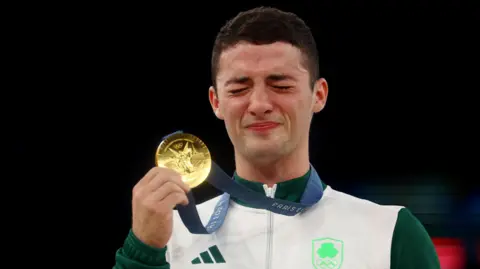 Reuters Rhys McClenaghan, holding gold medal, at the medals ceremony for the Olympics. 