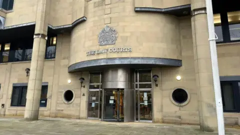 The outside of Bradford Crown Court's building, with the words "The Law Courts" written on the light-coloured stones front.