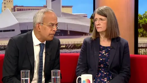 Max and Jane Figueiredo sit on the red sofa of BBC Breakfast