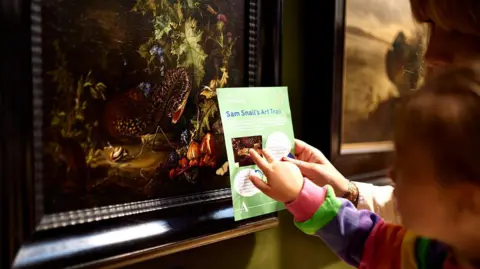 Ashmolean Museum, University of Oxford A child pointing at a Snail Trail information sign at the Ashmolean.