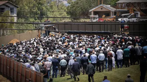 Getty Images People attend the burial service for Amin Abdullah, Mansour Kaziha and Nadir Awad at La Vista Memorial Park in National City on 21 May in San Diego, California. 