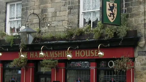 supplied The exterior of an old pub with dark red painted walls
