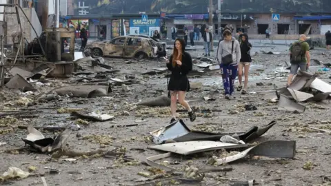 People walk among debris in Kyiv, following overnight Russian missile and drone strikes on Ukraine's capital. Photo: 24 May 2026