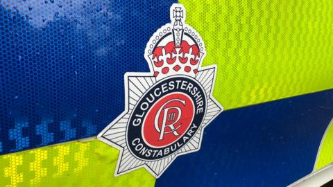 Image of the Gloucestershire Constabulary badge on the side of a police car