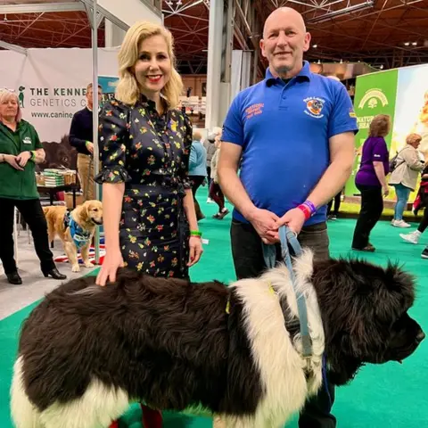 Pete Lewin Pete Lewis and Sally Phillips with a newfoundland at Crufts