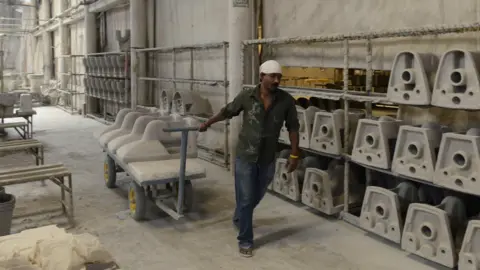 Getty Images An Indian worker building toilet parts