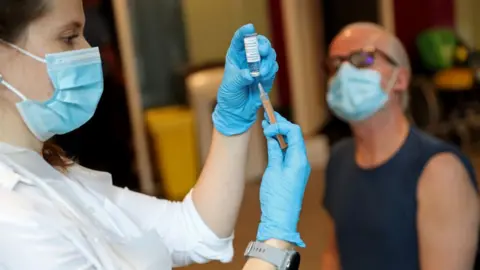 Getty Images Vaccinator prepares to give a Covid vaccine