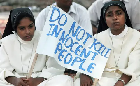 Getty Images Indian Christian nuns hold a placard as they listen to a speaker during a rally in New Delhi on October 1, 2008 in Karnataka