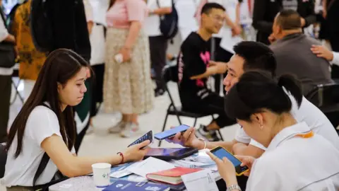 EPA-EFE/REX/Shutterstock Job seekers and recruiters at a job fair in Beijing, China.