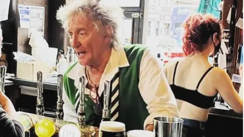 The Dirty Duchess Rod Stewart serving drinks in the Dirty Duchess