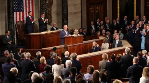 PA Media Wide angle shot of the King stood at the lectern in Congress. He is surrounding by the audience who are on their feet applauding