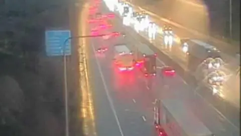 A number of cars and lorries on a dual carriageway in the rain. 