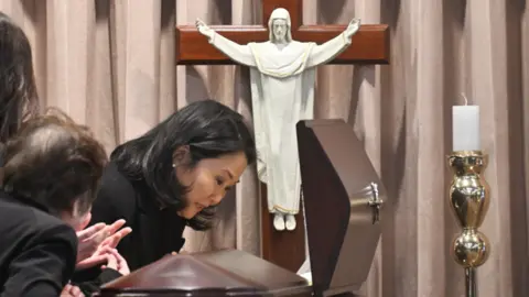 Getty Images Keiko Fujimori, daughter of former Peruvian President Alberto Fujimori, cries next to his coffin during a wake for his body at the Ministry of Culture in Lima.