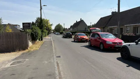 A street with cars parked down the right hand side which will soon be part of the trial