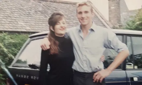 Alison Wild A woman with long hair and a black top stands next to a blond haired man with a light shirt