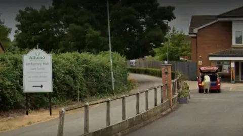 Google Images Exterior of Amberley Hall Care Home, shows a sign and the brick exterior.