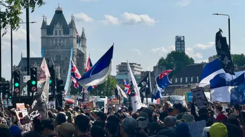 BBC Anti-China mega embassy protesters near the site, at Tower Bridge