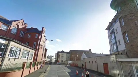 Lord Street, on the left is a large red building with lots of windows, it is a clear day.
